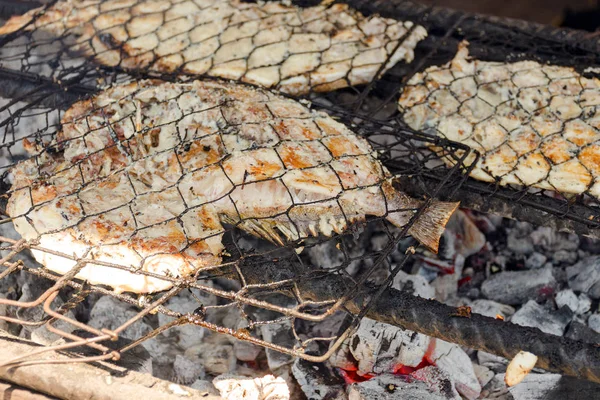 Fish barbecue. Cooking BBQ seafood on fire.