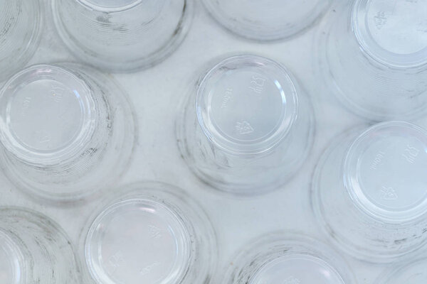 Dirty empty plastic glasses on a white background, top view.