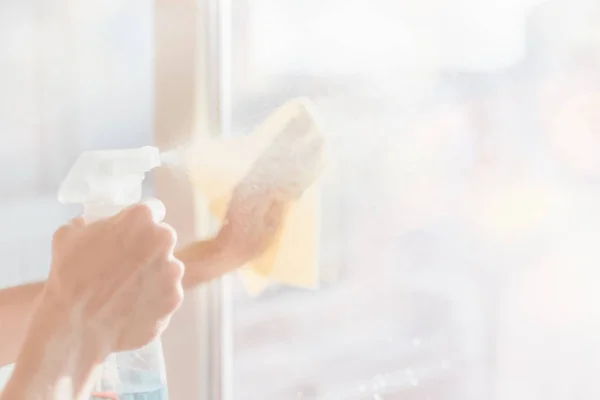 Rozmazaný obraz rukou s ubrouskem, čištění oken. Žena ruce mytí skla v oknech doma sprejem. — Stock fotografie