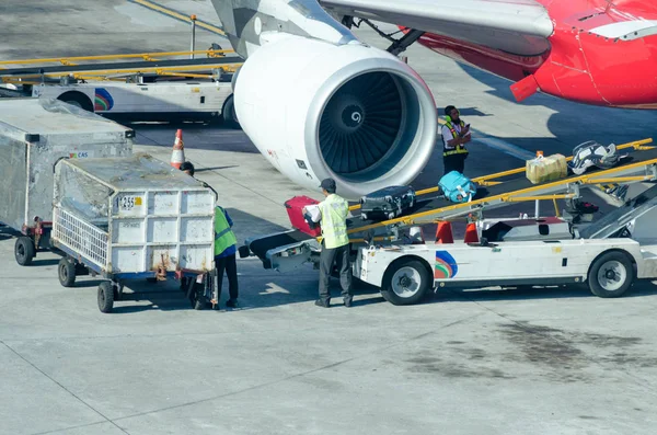 Man puts luggage on the conveyor belt on the plane. Royalty Free Stock Photos