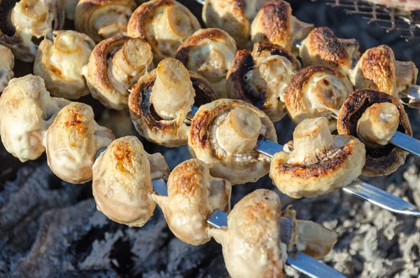 Champignon mushrooms on skewers are grilled on coals — Stock Photo, Image