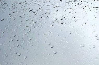 Yağmur damlaları cama düşer. 