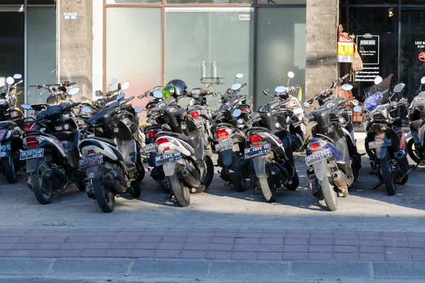 De nombreux scooters sont garés sur le trottoir . — Photo