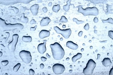 Sert bir demir yüzeyde büyük su damlaları. Metal üzerine yağmur lekeleri. Yakın çekim, üst manzara.