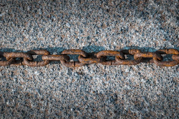 Alte rostige Kette liegend waagerecht auf grauem Asphaltgrund. — Stockfoto