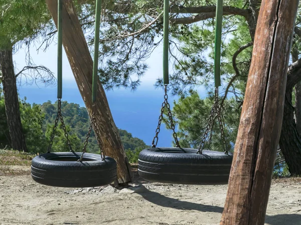 Duas oscilações de pneus nas árvores. Bela paisagem montesa — Fotografia de Stock