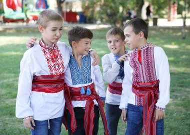 Ukrayna, Pokrov - 23 Ağustos 2019: Ulusal Bayrak Günü Kutlaması. Halk Ukrayna işlemeli gömlek giymiş dört erkek arkadaş sarılma ve gülme standı