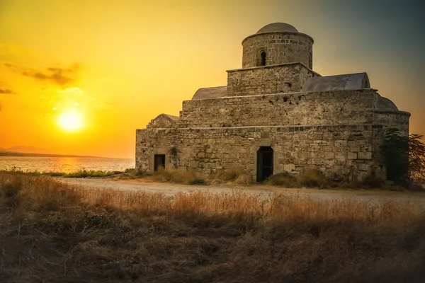 Antigo edifício histórico de pedra na costa do mar ao pôr-do-sol no norte de Chipre. Construindo no fundo do céu e do pôr do sol sobre o horizonte. Bela paisagem — Fotografia de Stock