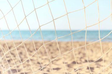Yaz plajı arka planında futbol topu ağları. Bulanık kumlu sahilin arka planına odaklan.