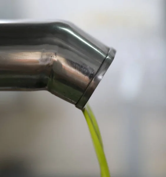 El proceso de producción de aceite de oliva en una fábrica de aceite moderna en el norte de Chipre. Aceite de oliva fresco procedente de una tubería de acero inoxidable — Foto de Stock
