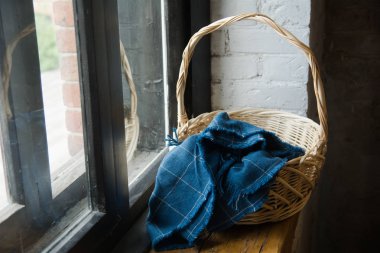 Soty pencere üzerinde mavi bir bez dokuma sepet kaplı.