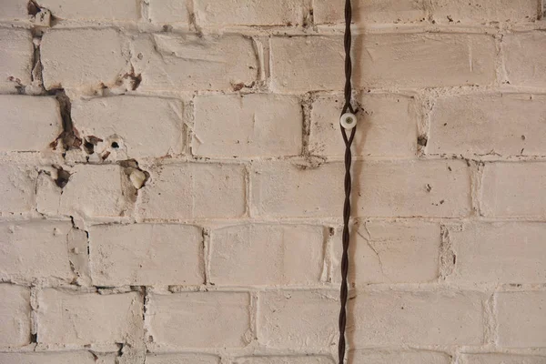 白色砖墙上的编织老式电线 — 图库照片