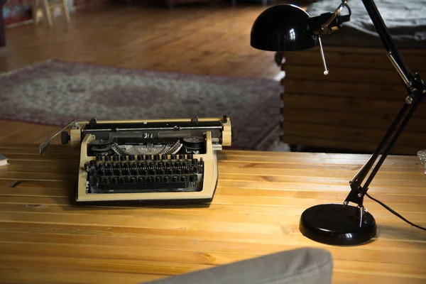 Eine Alte Schreibmaschine Und Eine Lampe Auf Einem Lackierten Holztisch — Stockfoto
