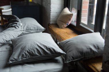 Gri yastık yatak yatak odası penceresinde.