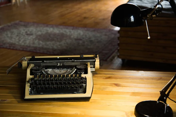 Eine Alte Schreibmaschine Und Eine Lampe Auf Einem Lackierten Holztisch — Stockfoto