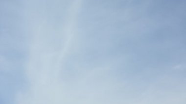 Bulutlar mavi gökyüzüne hızlı hareket ediyor.