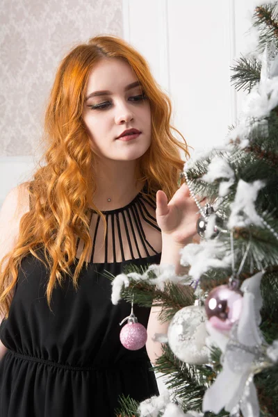 クリスマスのモミで赤い髪を持つ若い女性 — ストック写真
