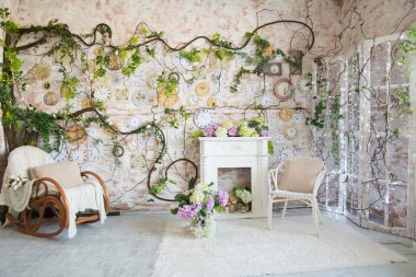 Bir şömine ve duvardaki bir saat ile bir odası iç tasarım. Hasır sandalye ve bir battaniye bir vazoda çiçekler gibi sandalyeyle