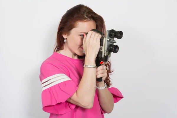 Porträt einer Frau mit Retro-Filmkamera auf weißem Hintergrund — Stockfoto