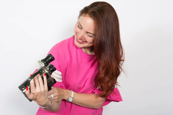 Porträt einer Frau mit Retro-Filmkamera auf weißem Hintergrund. — Stockfoto