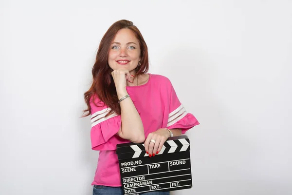 Redhead woman in pink top with movie board isolated — Stock Photo, Image