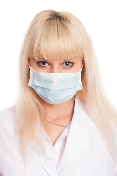 Close up de uma jovem enfermeira em máscara olhando para a câmera . — Fotografia de Stock