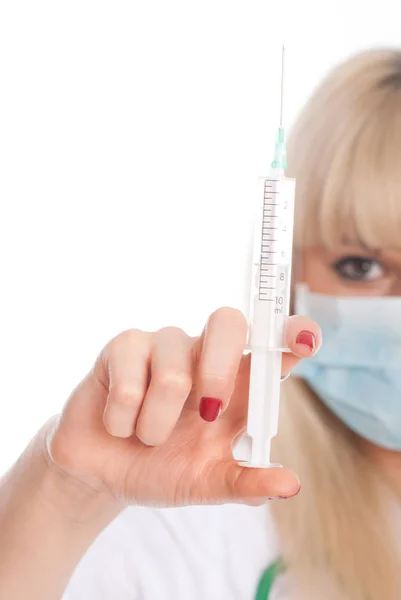 Close up of a young blonde nurse in a mask with a syringe. — Stock Photo, Image