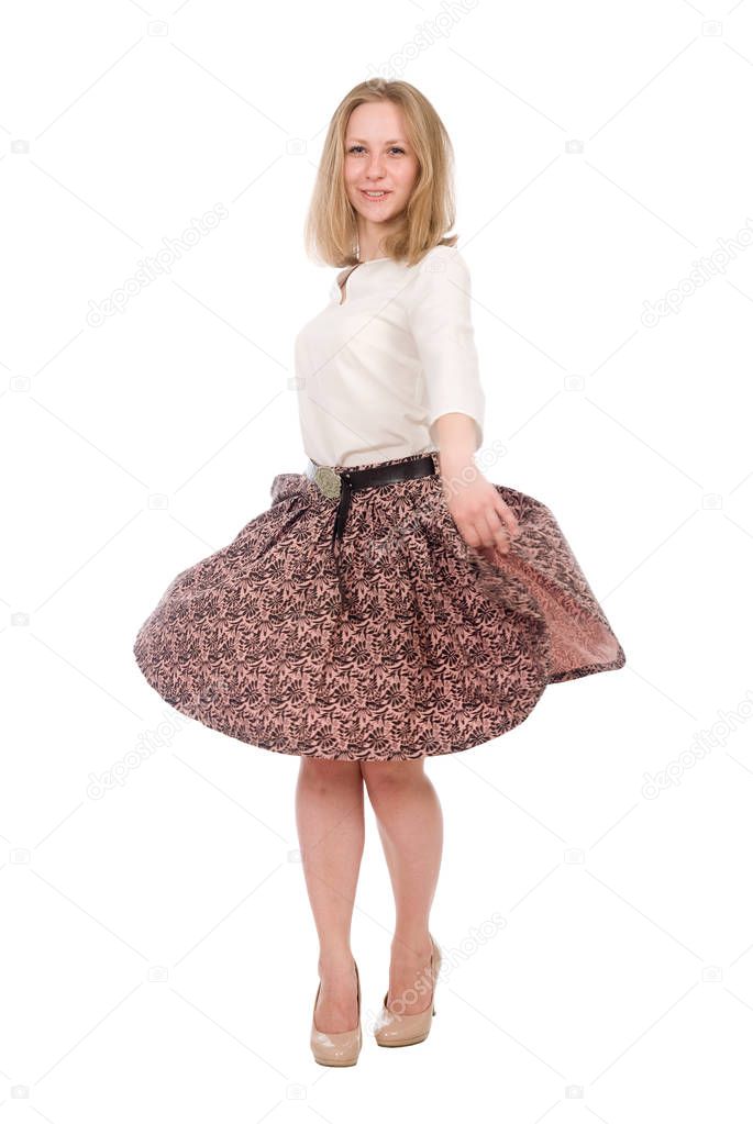 Portrait of a young woman with a skirt circling in full growth isolated over a white
