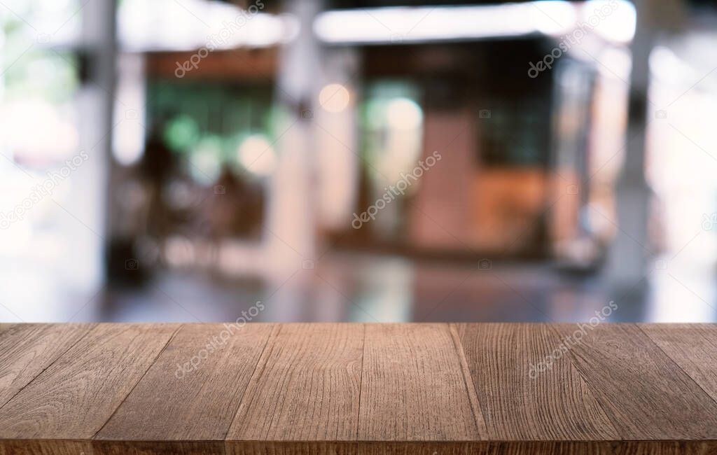 Empty dark wooden table in front of abstract blurred bokeh background of restaurant . can be used for display or montage your products.Mock up for space