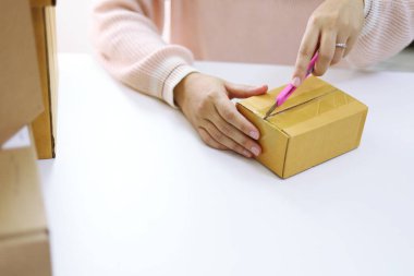 İnternetten alışveriş yaptıktan sonra kutuları açan kadın.