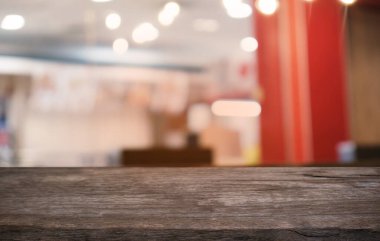 Restoranın soyut bulanık arka planının önündeki boş, siyah ahşap masa. Ürünlerinizi görüntülemek ya da montajlamak için kullanılabilir.