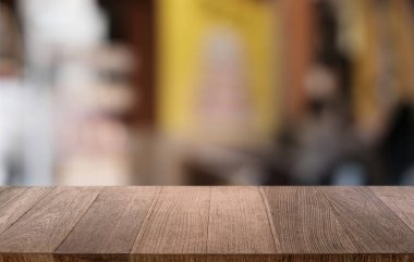 Restoranın soyut bulanık arka planının önündeki boş, siyah ahşap masa. Ürünlerinizi görüntülemek ya da montajlamak için kullanılabilir. 