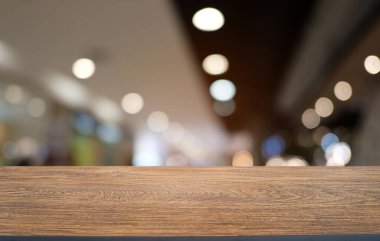 Restoranın soyut bulanık arka planının önündeki boş, siyah ahşap masa. Ürünlerinizi görüntülemek ya da montajlamak için kullanılabilir. 