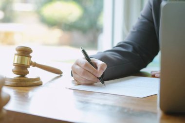 Hukuk danışmanı müvekkiline tokmak ve hukuk hukuku ile imzalanmış bir sözleşme sunar. Adalet ve avukat kavramı