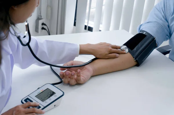 医師は老婦人患者の動脈血圧をチェックします — ストック写真
