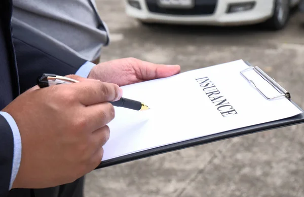 Loss Adjuster Insurance Agent Inspecting Damaged Car