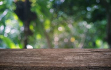 Restoranın soyut bulanık arka planının önündeki boş, siyah ahşap masa. Ürünlerinizi görüntülemek ya da montajlamak için kullanılabilir. 