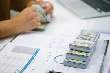 Yatırım çizelgelerini analiz eden ve belgelerin üzerindeki hesap makinesi tuşlarına basan bir işadamı. Muhasebe Kavramı