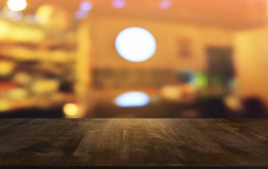Restoranın soyut bulanık arka planının önündeki boş, siyah ahşap masa. Ürünlerinizi görüntülemek ya da montajlamak için kullanılabilir. 