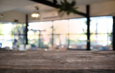 Restoranın soyut bulanık arka planının önündeki boş, siyah ahşap masa. Ürünlerinizi görüntülemek ya da montajlamak için kullanılabilir.