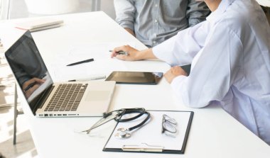 Tıp doktoru, doktor ekibine teşhisi açıkla ve önemli belgeleri inceleyen panoları göster.