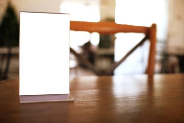 Bar restoranının kafesinde ahşap masada duran menü çerçevesi. Metin pazarlama promosyonu için boşluk