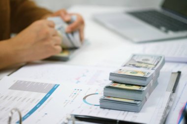 Yatırım çizelgelerini analiz eden ve belgelerin üzerindeki hesap makinesi tuşlarına basan bir işadamı. Muhasebe Kavramı