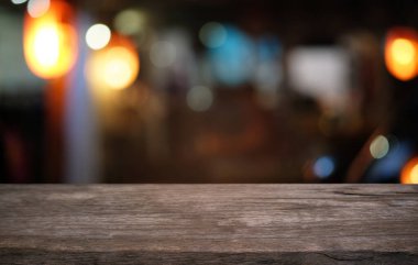 Restoranın soyut bulanık arka planının önündeki boş, siyah ahşap masa. Ürünlerinizi görüntülemek ya da montajlamak için kullanılabilir. 