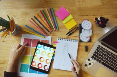 Moda tasarımcısı atölyedeki yeni koleksiyonun taslağı olarak çalışıyor. Yaratıcı Tasarım Konsepti.