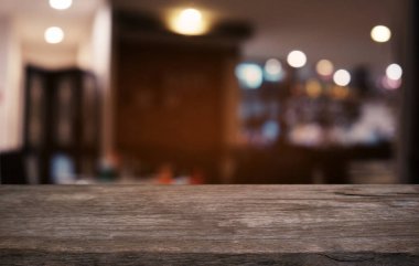 Restoranın soyut bulanık arka planının önündeki boş, siyah ahşap masa. Ürünlerinizi görüntülemek ya da montajlamak için kullanılabilir.