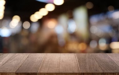 Restoranın soyut bulanık arka planının önündeki boş, siyah ahşap masa. Ürünlerinizi görüntülemek ya da montajlamak için kullanılabilir. 