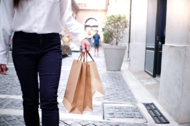 Asyalı kızlar ellerinde alışveriş torbaları tutuyor. Alışveriş merkezinde tüketim yaşam tarzı kavramı