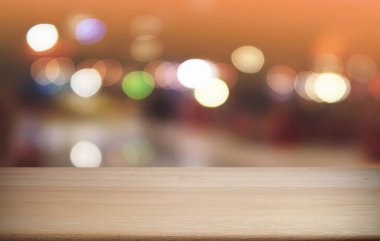 Restoranın soyut bulanık arka planının önündeki boş, siyah ahşap masa. Ürünlerinizi görüntülemek ya da montajlamak için kullanılabilir. 