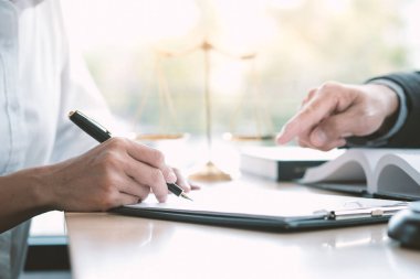 Hukuk danışmanı müvekkiline tokmak ve hukuk hukuku ile imzalanmış bir sözleşme sunar. Adalet ve avukat kavramı